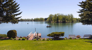 A peaceful lake framed by trees, photographed by Billie Parsley-Mitha